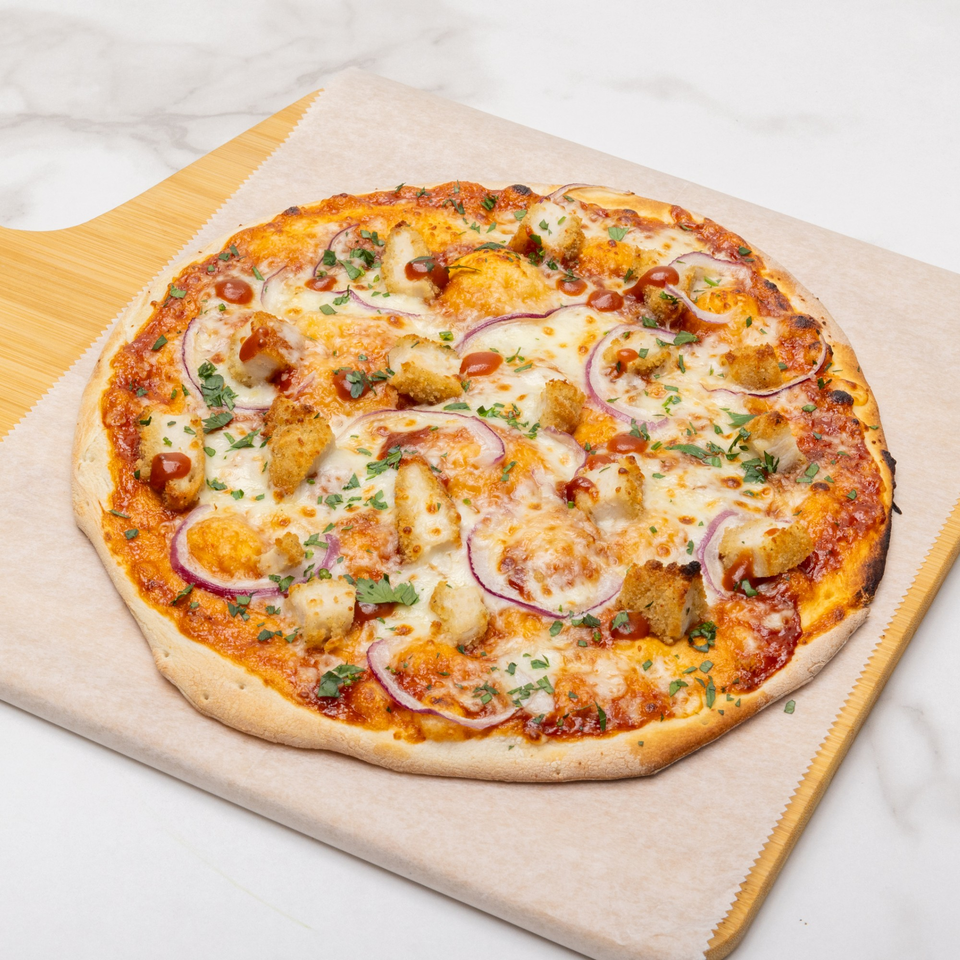BBQ chicken pizza with red onions, cilantro, and a drizzle of barbecue sauce on a wooden peel.
